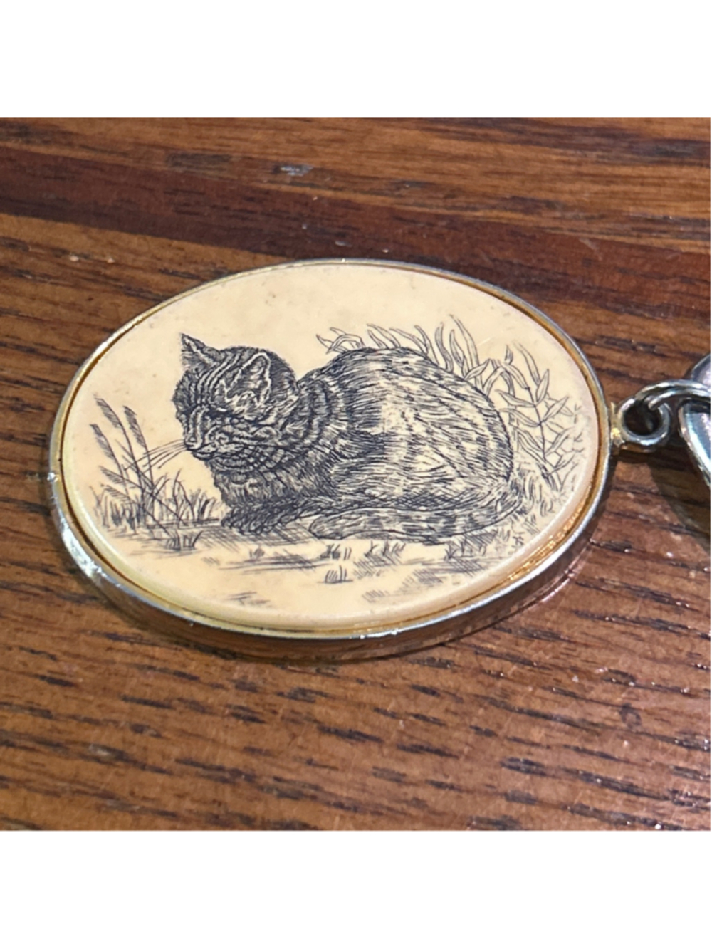 Unisex vintage Barlow cat keychain featuring an engraved resting cat